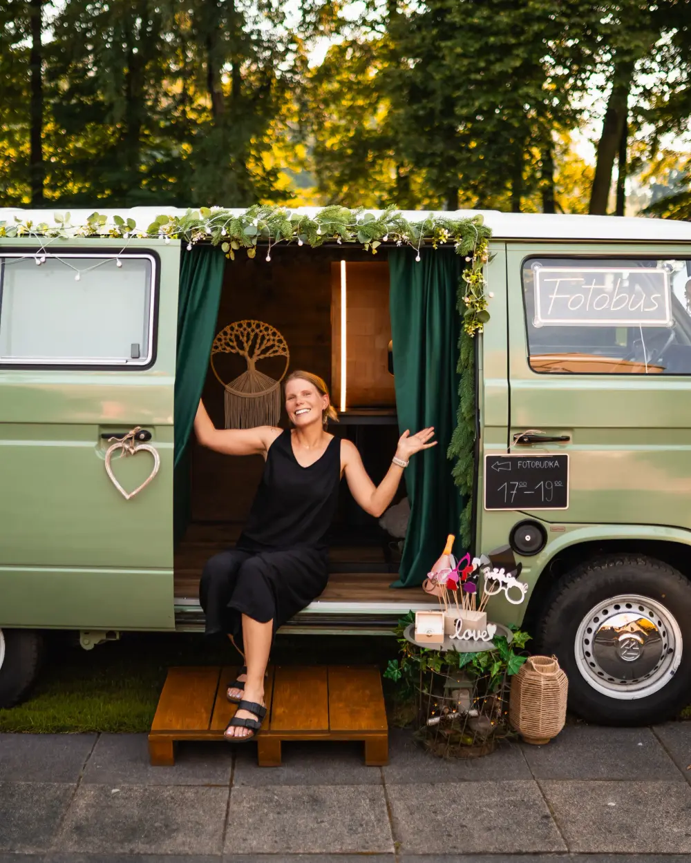 Chwila relaksu w drzwiach szałwiowego VW T3 w leśnej scenerii